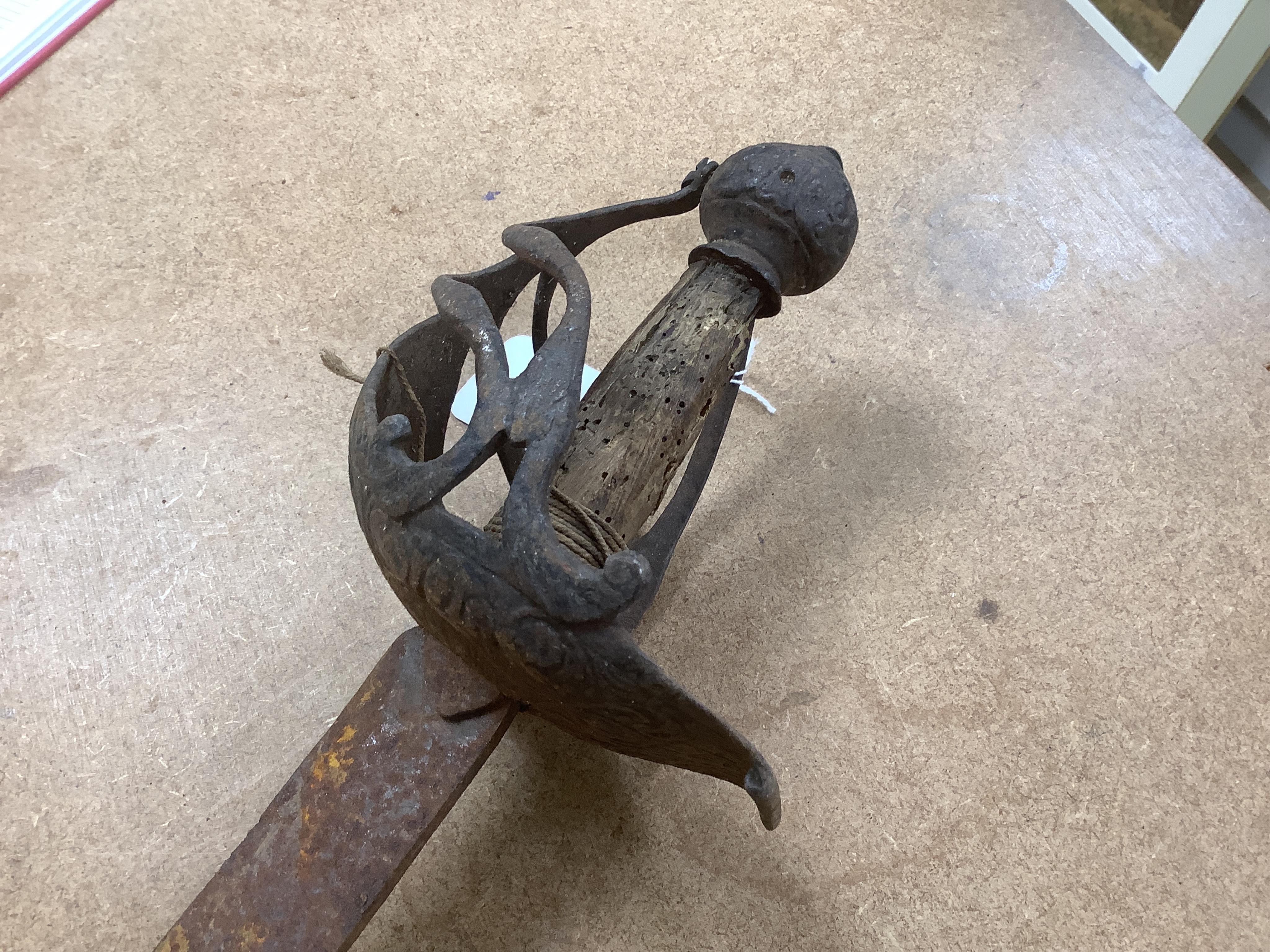 An English Civil War period cavalry officer’s sabre, curved single edge blade, struck with crescent moon, ‘mortuary’ hilt chiselled with scrolling foliage, swollen chiselled pommel, wooden grip, blade 71.5cm. Condition -